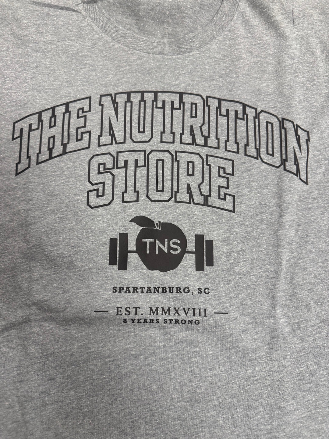 Heather gray collegiate TNS shirt — front graphic detail